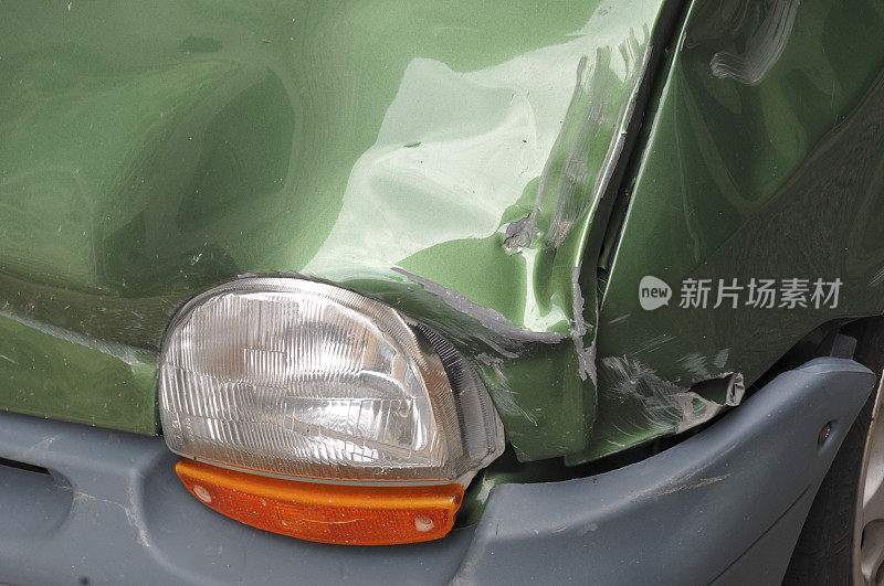 带有前灯的绿色汽车前部受损