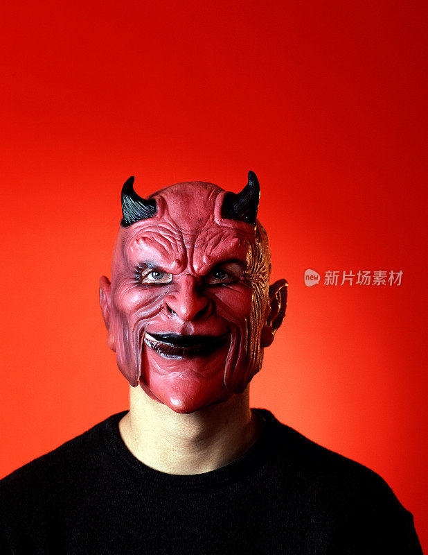 一个戴着红色恶魔面具的人，戴着犄角对抗红色的后背