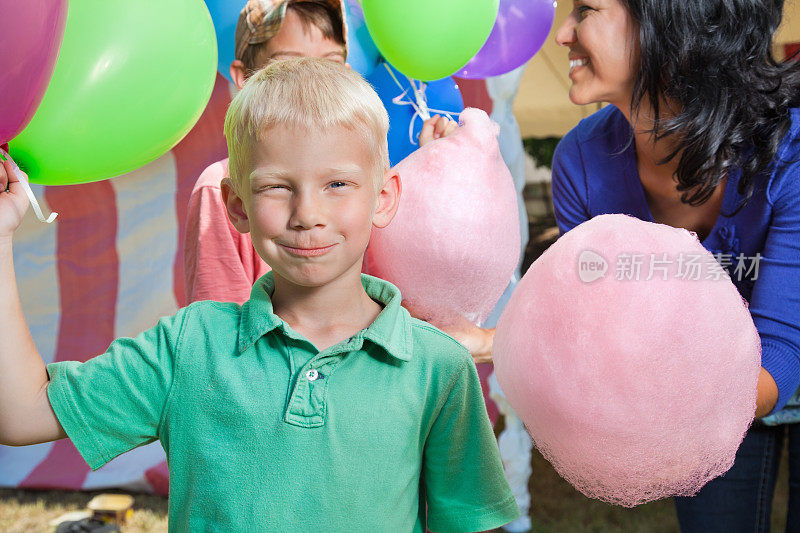 小男孩在嘉年华或马戏团拿着气球傻笑