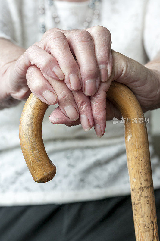 手持手杖的老妇人的手