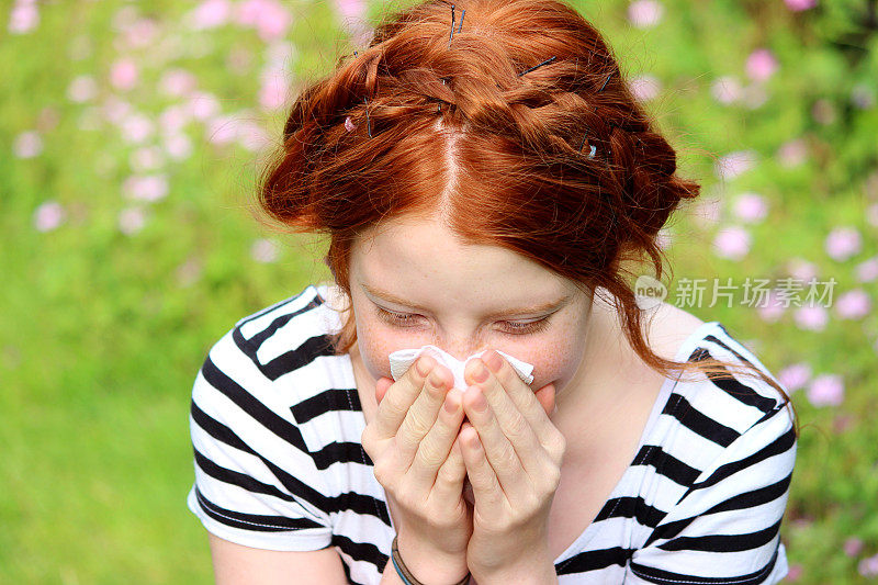 花园里的女孩得了花粉病，擤鼻涕，打喷嚏，过敏