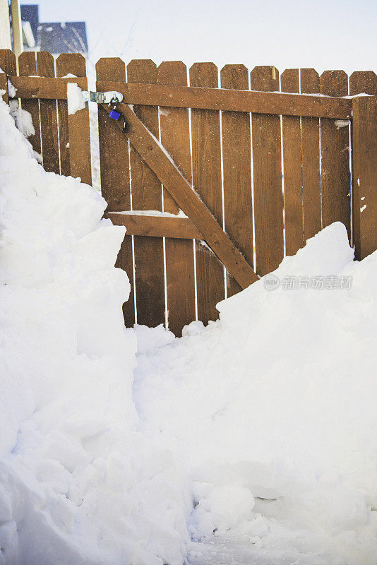 暴风雪过后，雪靠着花园篱笆堆得很高。美国科罗拉多州