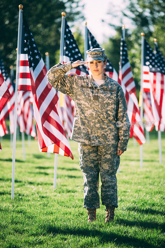 在美国国旗前敬礼的美国女兵