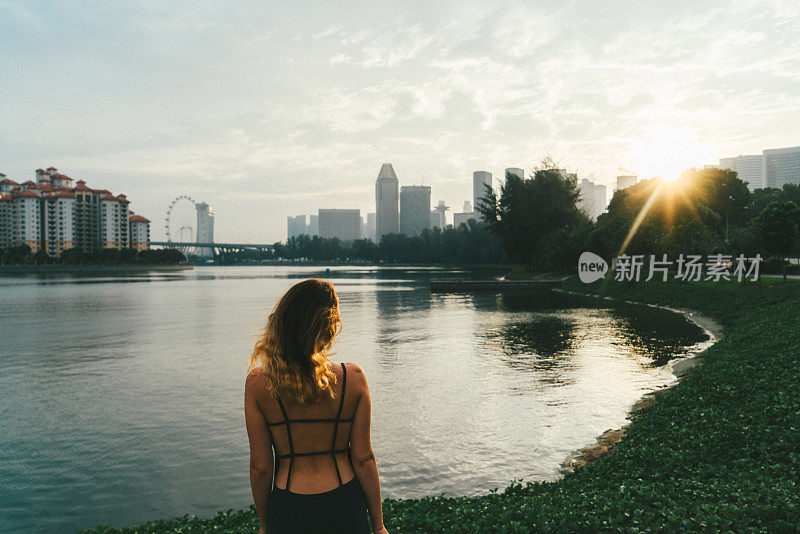 日落时分，一名女子望着新加坡的滨海湾