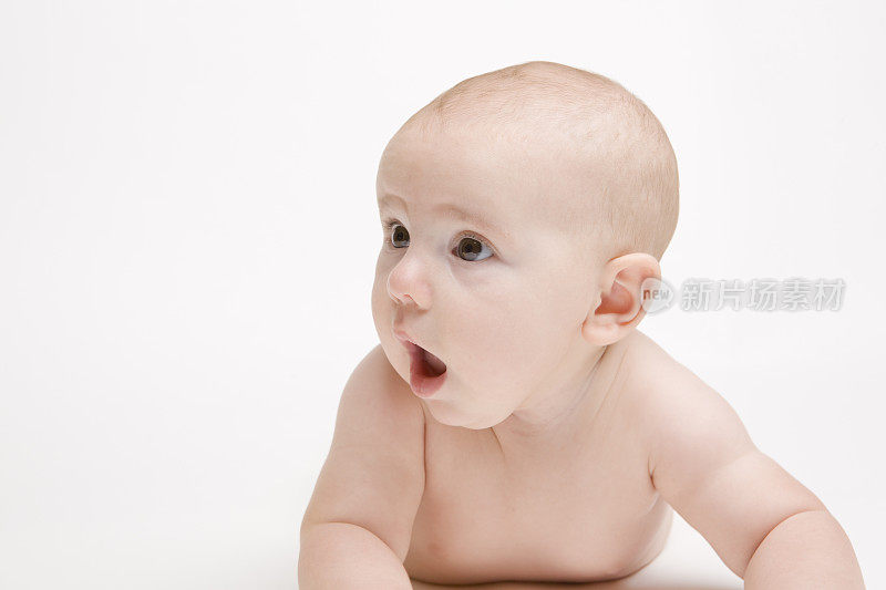 在普通的背景下，惊讶的婴儿张着嘴