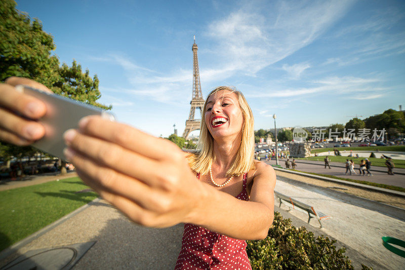 年轻女子在巴黎埃菲尔铁塔自拍