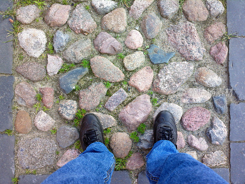 双脚踩在鹅卵石上。