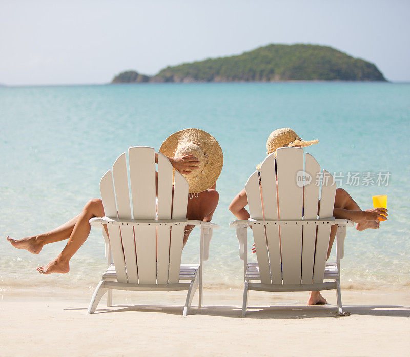 两个完全认不出来的女人坐在沙滩椅上欣赏加勒比海的景色
