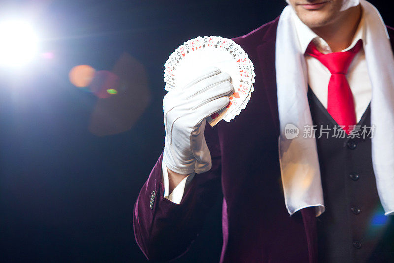 魔术师的腹部显示扇形的卡片在黑色的背景。魔术师，变戏法的人，有趣的人，黑魔法，幻觉特写