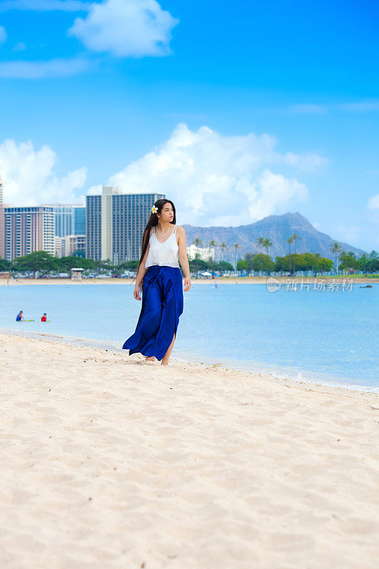 微笑的混血少女走在檀香山海滩，夏威夷