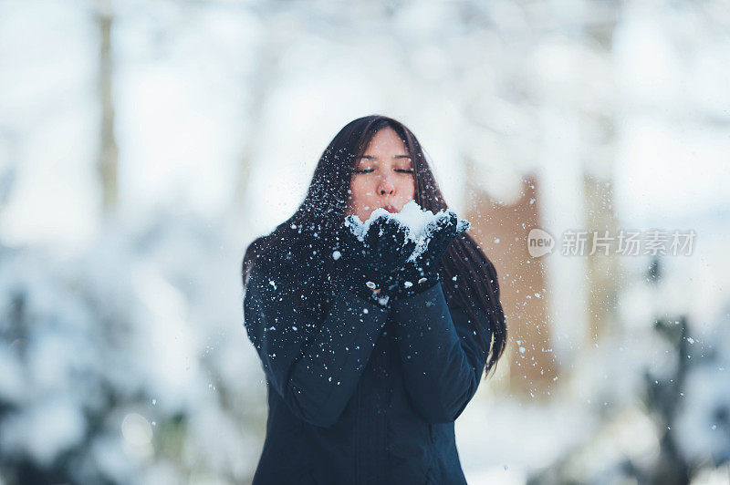 年轻女子在雪中玩耍