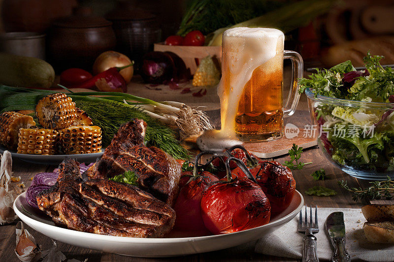 木桌上放着烤肉、西红柿、玉米、青菜、沙拉、鸭肉和大蒜。