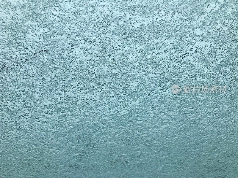 一扇窗户被冰覆盖的背景，由于冻雨。
