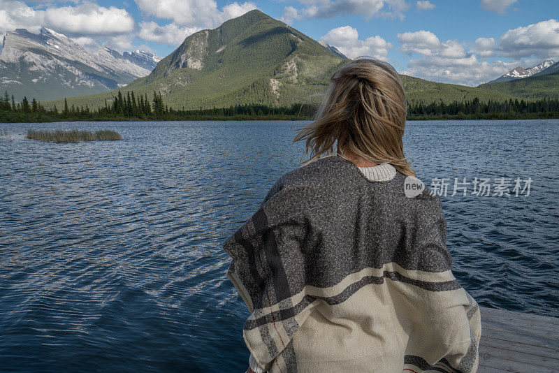 年轻女子在湖边码头凝望大自然