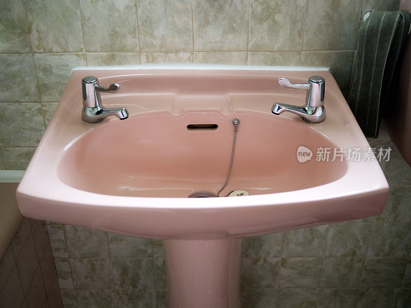 绿色浴室里的复古粉色水槽。