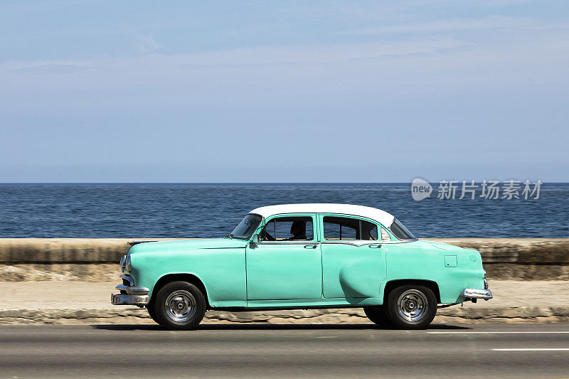在古巴哈瓦那，一辆绿色的老式美国车在马雷孔高速行驶