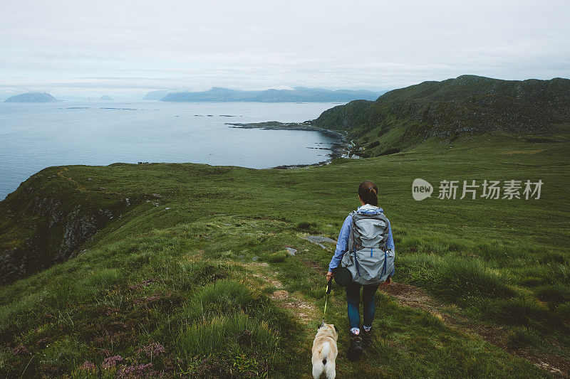 妇女和狗在挪威北部岛屿徒步旅行