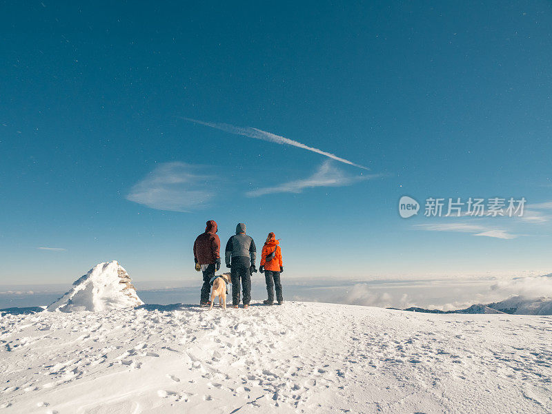 冬季日出时，阿尔卑斯山登山队正在高海拔的山峰上观赏风景