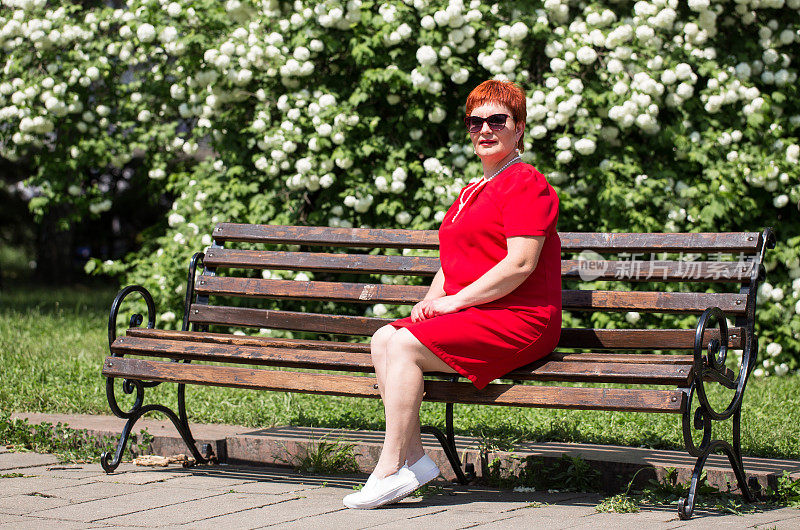 一个女人坐在公园的长椅上。