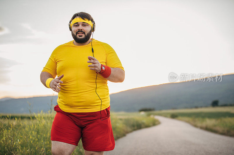 一个身材高大的男人在日落时分在街上慢跑