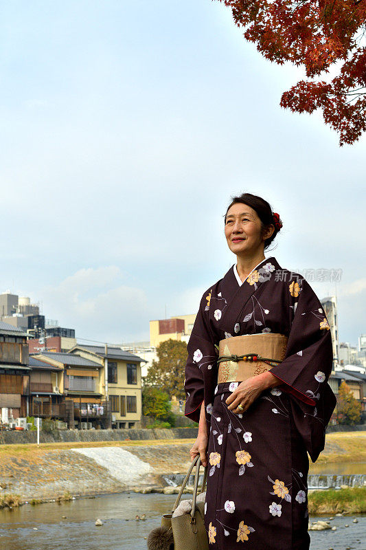 穿着和服的日本妇女沿着京都的加茂河行走