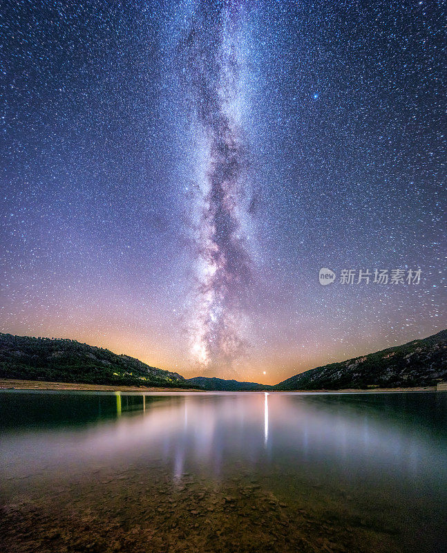 银河的景观反映在一个湖在夜晚的背景