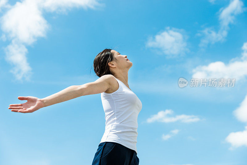 年轻女子双手伸向天空