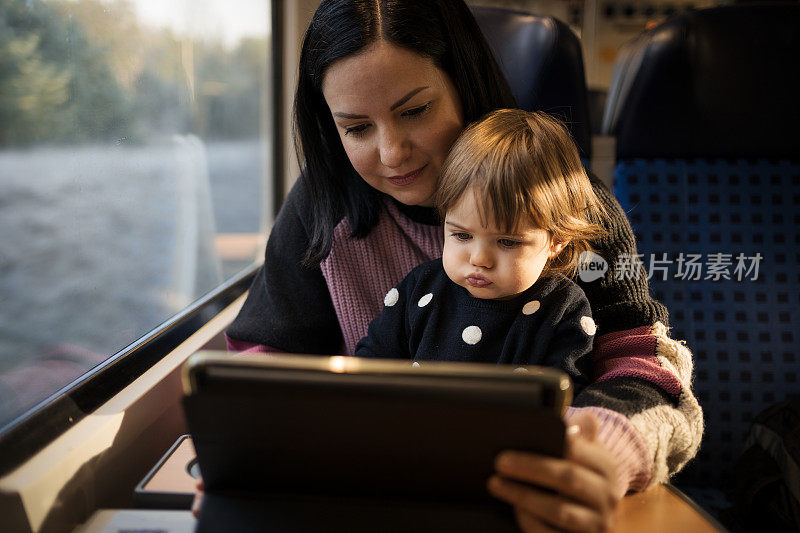 一位年轻的母亲带着她的女儿乘火车旅行，穿过美丽的风景