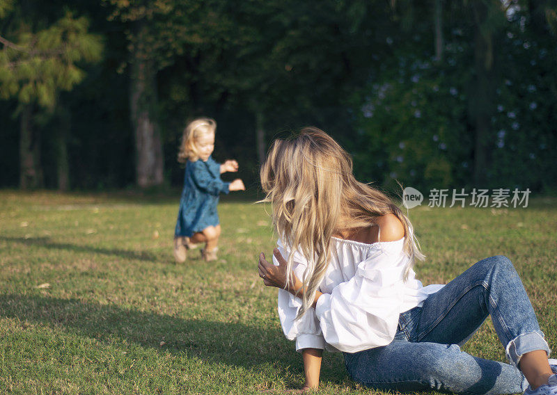 妈妈和她可爱的小女孩在公园里一起玩耍的照片