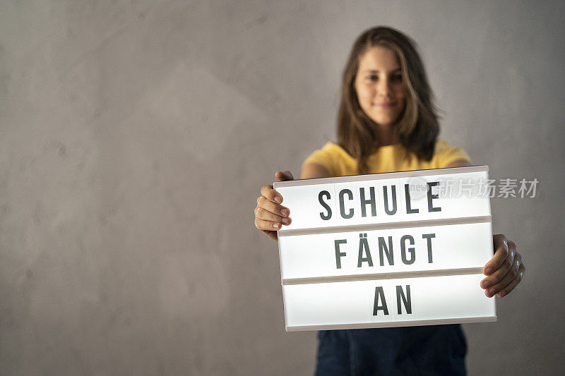 一名少女举着用德语写着“开学了”的牌子，意思是“开学了”