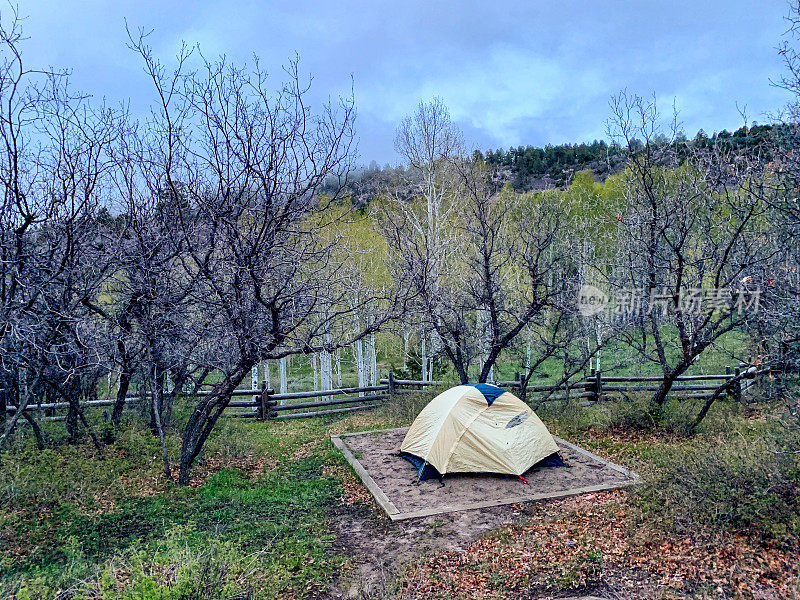 在西科罗拉多州的山坡和森林附近的一个有围栏的露营地里，一个搭好的帐篷