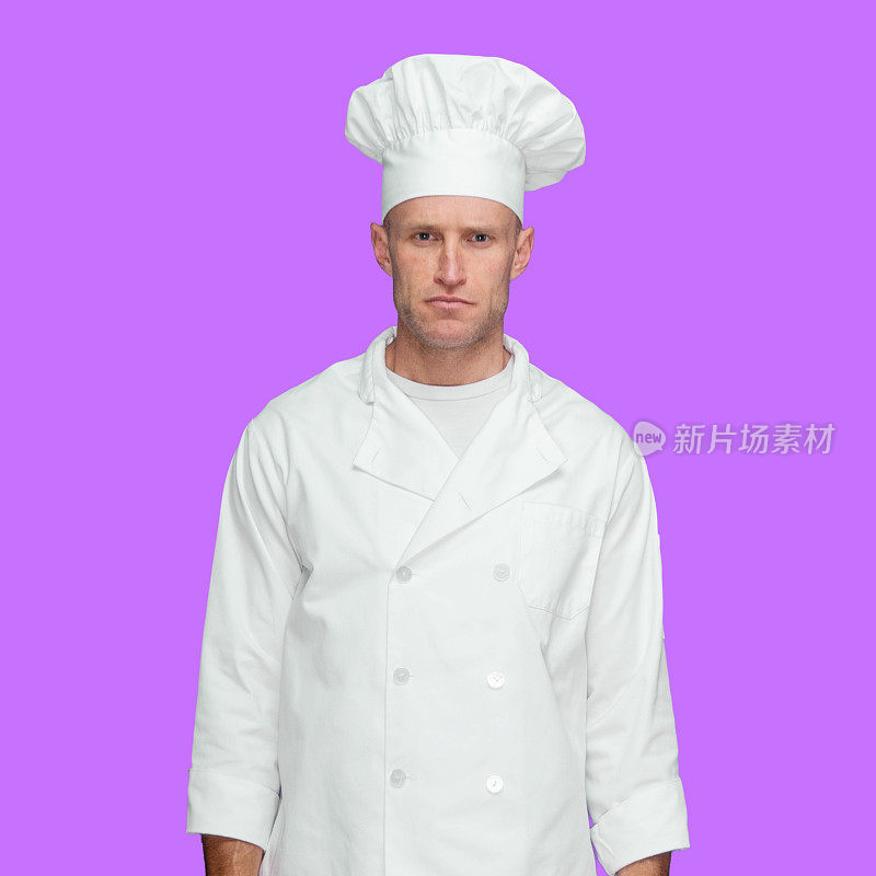 白种年轻男厨师站在前面，前面是紫色的背景，穿着裤子