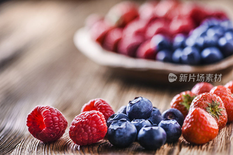 木碗里的林果。蓝莓、树莓、草莓