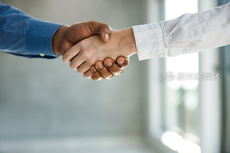 企业家在办公室握手的特写。