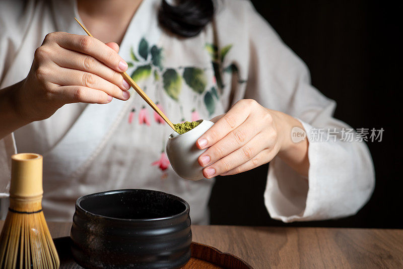 女人用传统的茶道用具制作抹茶绿茶