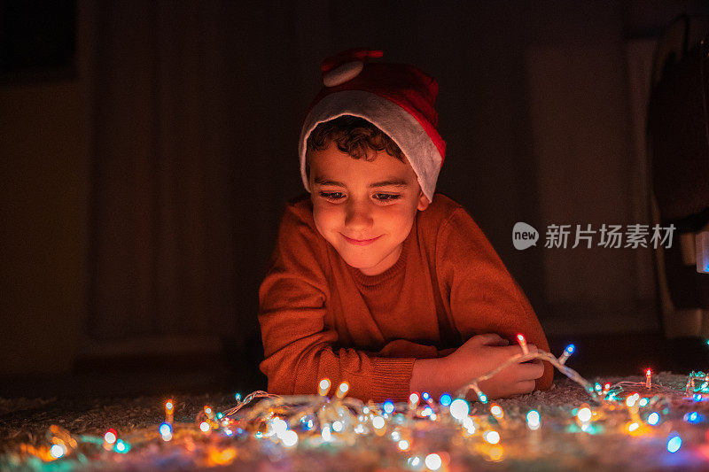 男孩在家里玩圣诞彩灯