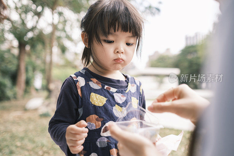 可爱的中国女孩在公园里吃糖果