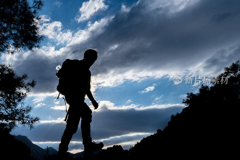 老人背双肩包山水剪影