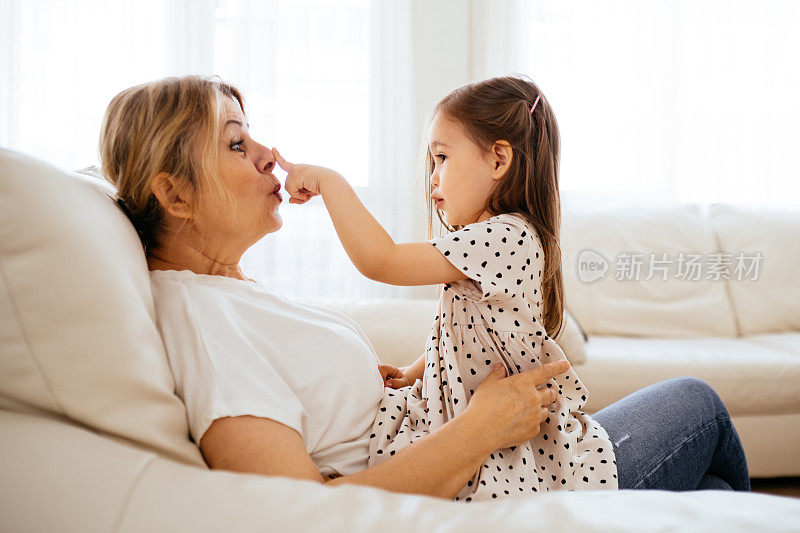 快乐的中年祖母抱着可爱的小孙女