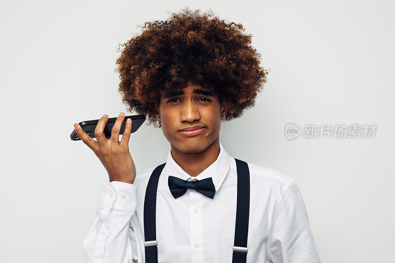 非洲裔美国人，留着非洲式发型，穿着白衬衫，使用智能手机