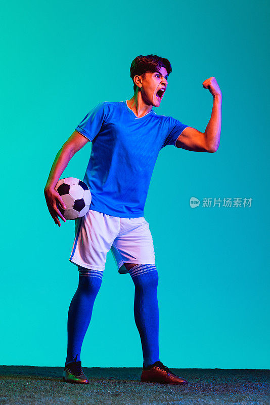 年轻的职业足球运动员被孤立在蓝色的背景中。团队领导