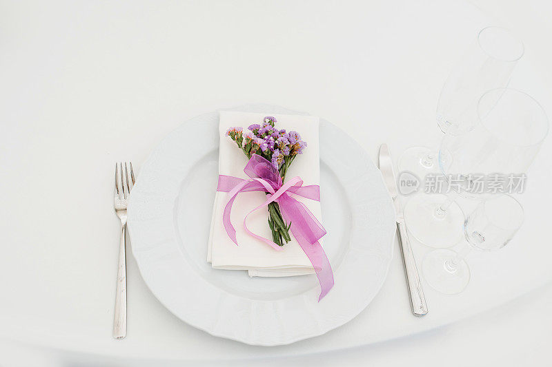 在派对婚礼上用鲜花装饰的盘子、叉和刀的特写。