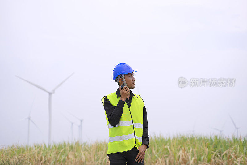 电力工地的蓝领工人。风车。