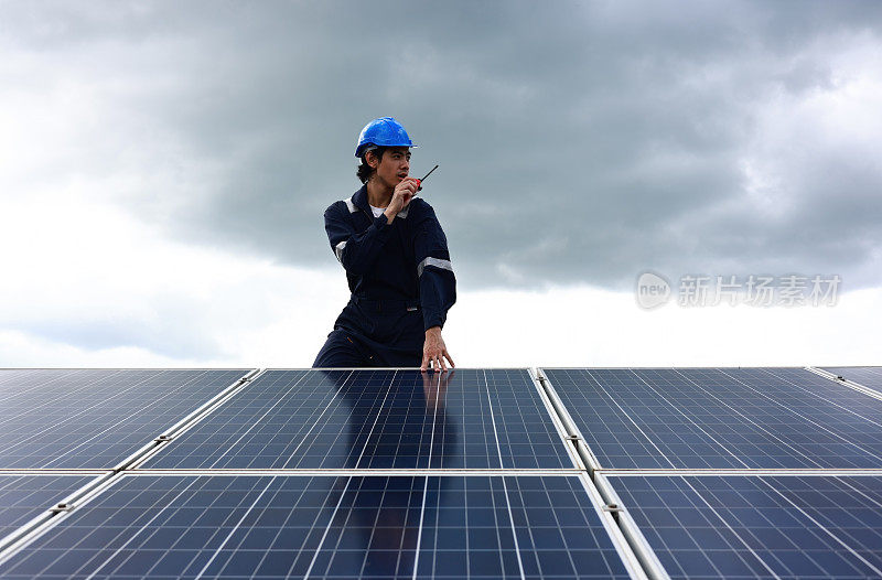 太阳能工程师佩戴安全PPE在太阳能农场工作，每天检查太阳能电池板，可再生和绿色能源的概念