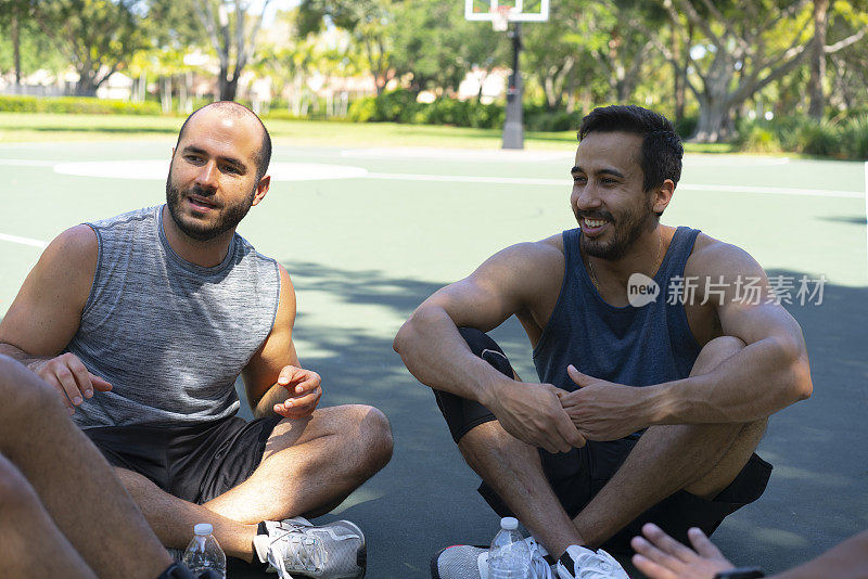 业余篮球运动员在户外篮球场上愉快地交谈