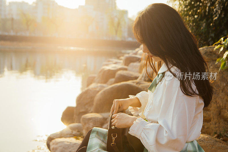 美丽的大学生在夕阳湖畔