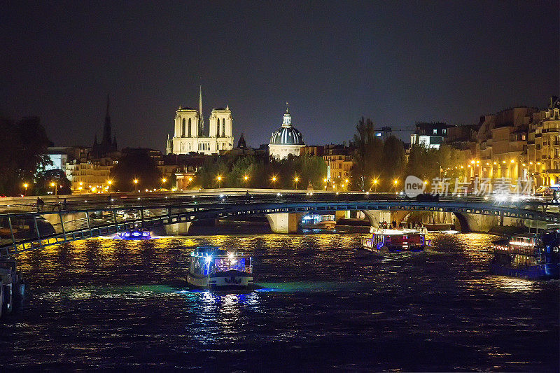 宏伟的巴黎圣母院新桥的夜景和塞纳河上的游船