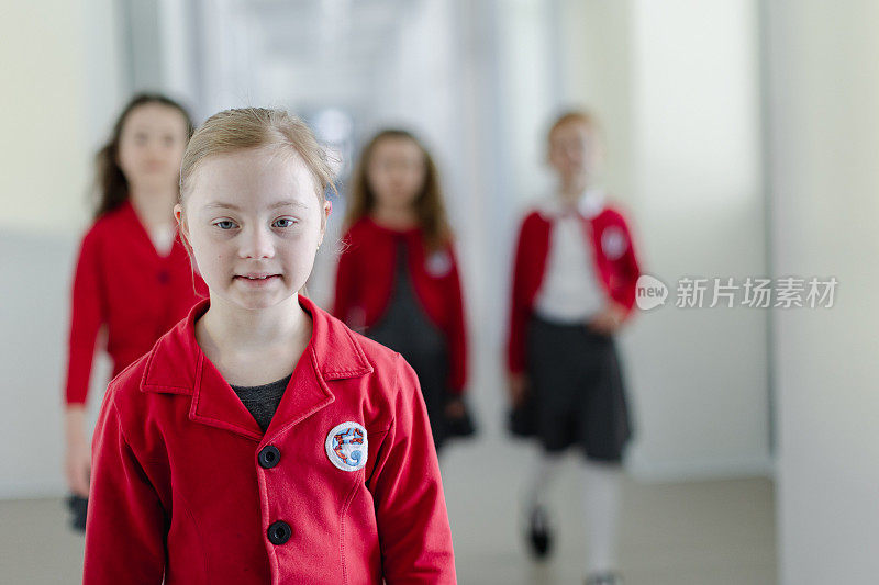 穿着制服的唐氏综合征快乐女学生走在学校走廊上，同学们跟在她后面。
