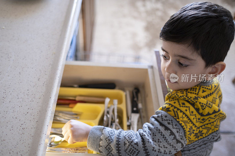 小男孩正在卸载洗碗机