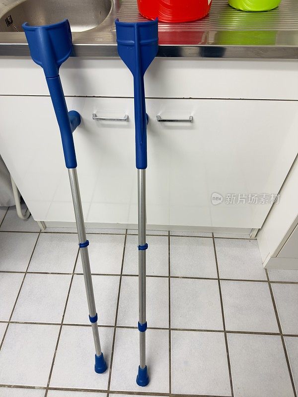 两根蓝色的拐杖立在厨房的水槽边